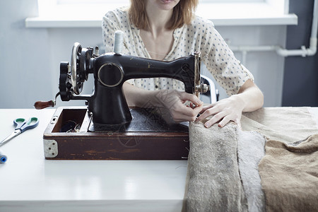 旧缝纫机上妇女纺织品的剪裁视图图片