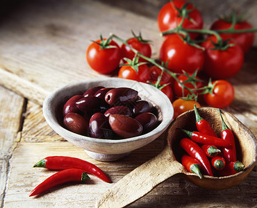 黑橄榄红辣椒和生锈碗木板的番茄图片