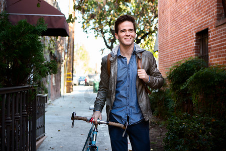 快乐的年轻人在行道上骑着自车漫步图片