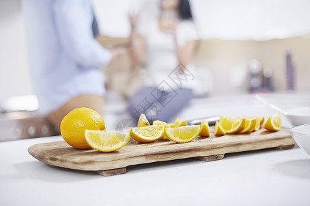 在年轻夫妇面前厨房柜台上的四角橘子图片