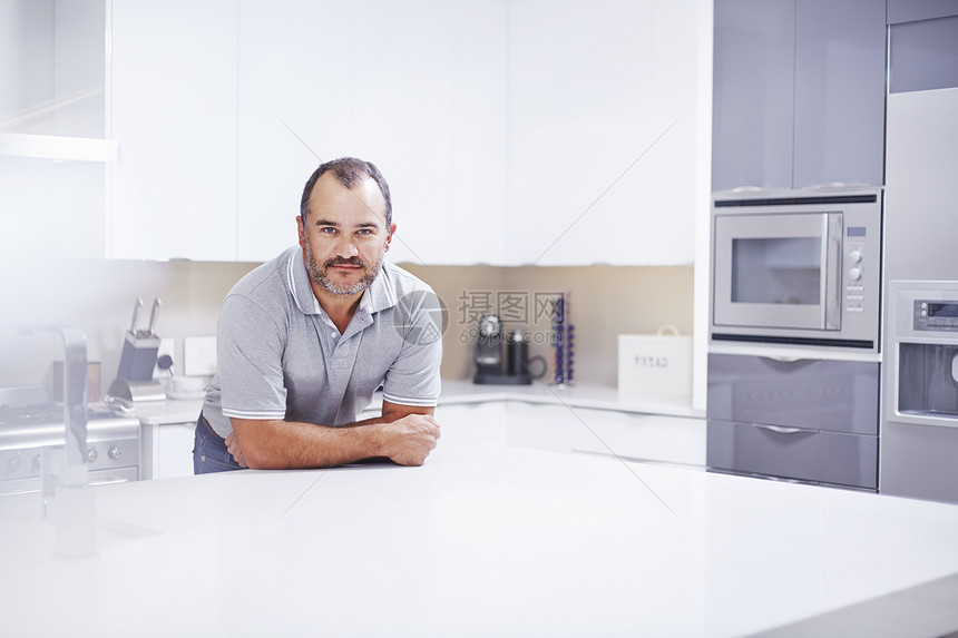 仰靠厨房柜台的成熟男人肖像图片