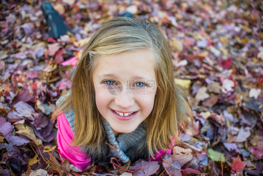 女孩躺在花园的秋叶上图片