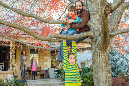 父亲和儿女在园中爬树图片