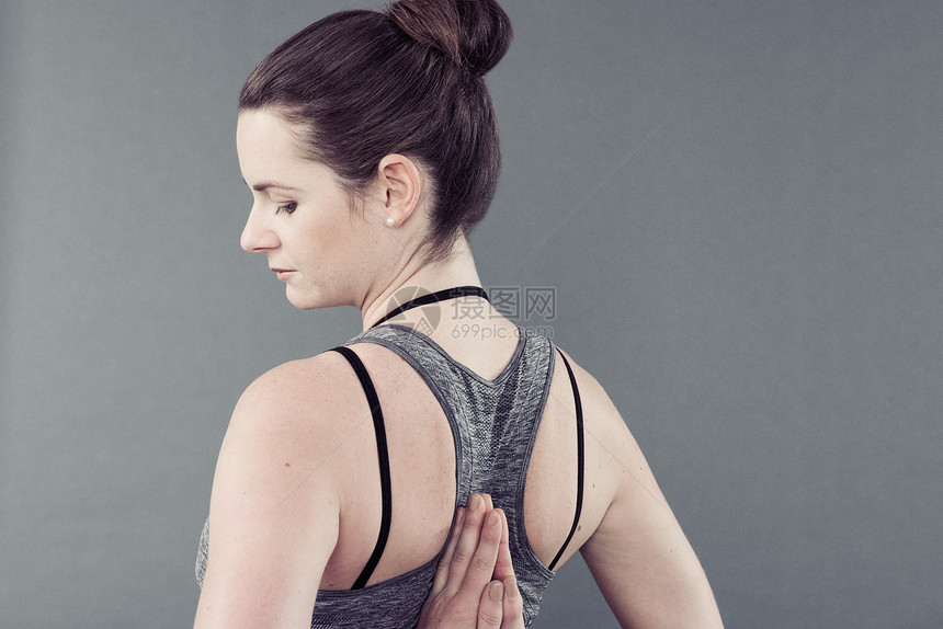 参加瑜伽的青春妇女灰色背景图片