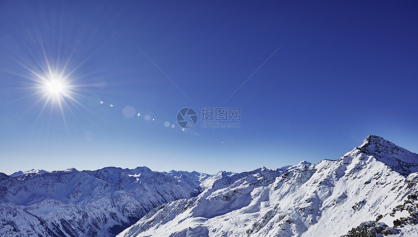 太阳和蓝色天空在雪覆盖的山上高视阳光和蓝色天空GaislachkogelSoeldenTyrool奥地利图片