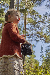 身着旧衣服在森林中篮子的女童图片