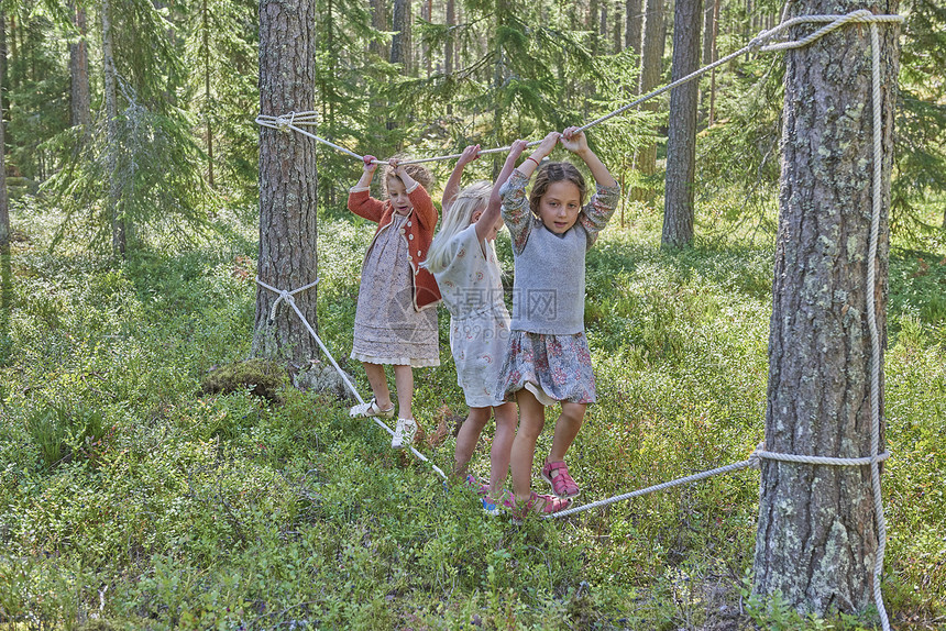 女孩穿着在森林绳上平衡的旧衣服图片