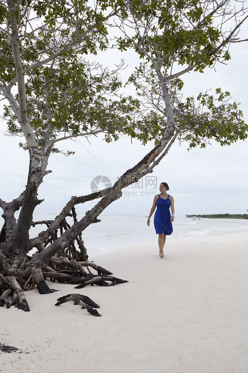 古巴在海滩上漫步的年轻女子图片
