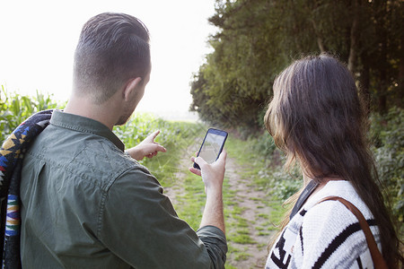 双人用智能手机在现场航行的双肩视线图片