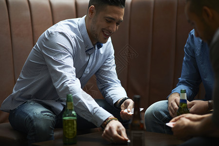 男人在英国传统酒吧打牌时把硬币放在桌上图片