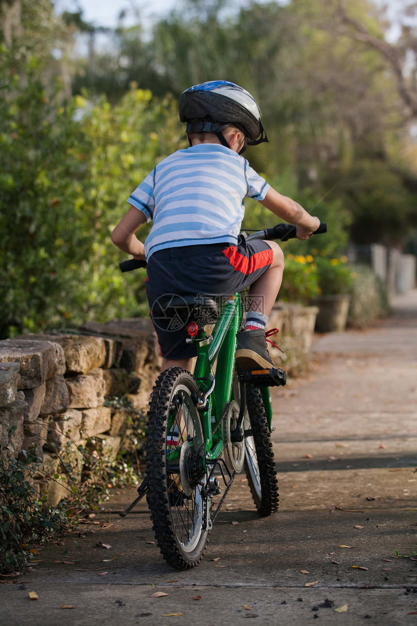 在路边骑自行车的男孩图片