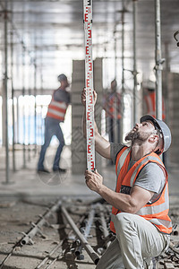 标尺测量建筑结构的年轻建筑师图片