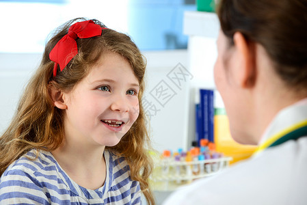 女孩在诊所与医生微笑交流图片
