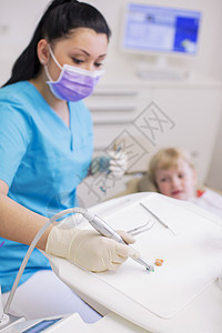 在牙科诊所对女孩进行牙科治疗的医生图片