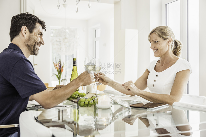 坐在桌边的一对夫妇拿着酒杯庆祝图片