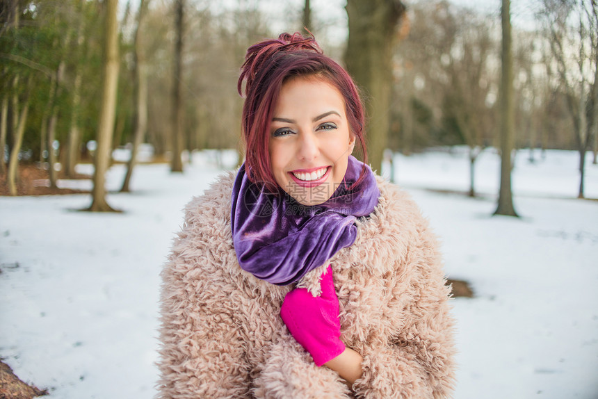 年轻女人在雪覆盖的公园里图片
