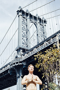 在美国纽约曼哈顿桥前冥想的男人图片