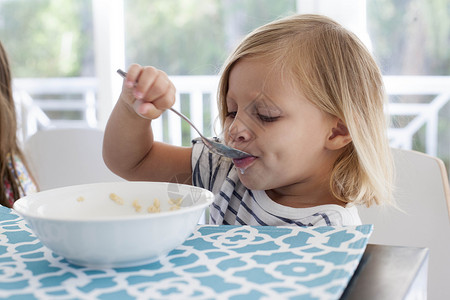女孩用勺子碗吃早餐图片