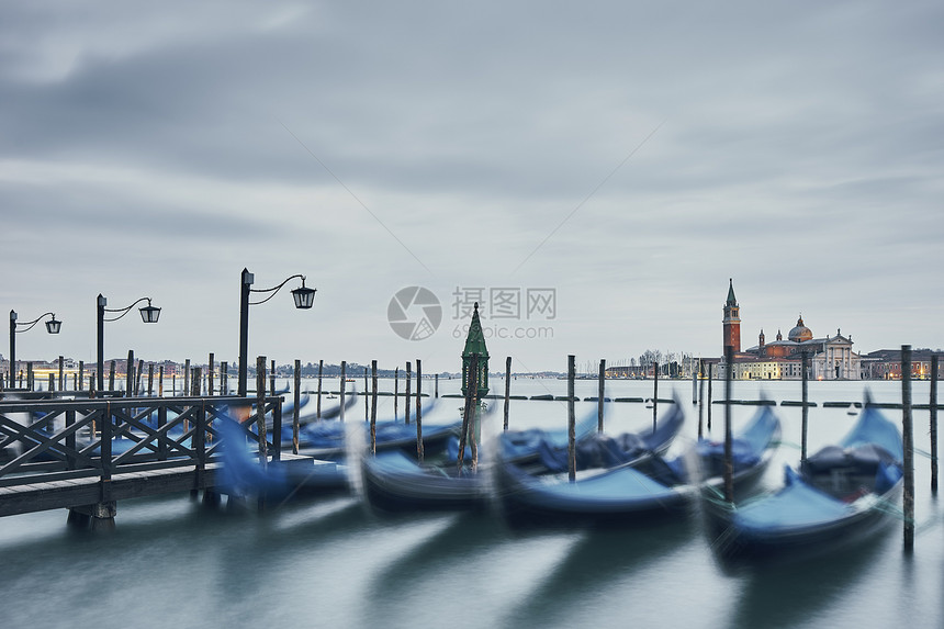 模糊的平底船和意大利威尼斯圣乔治马焦雷教堂的远景图片