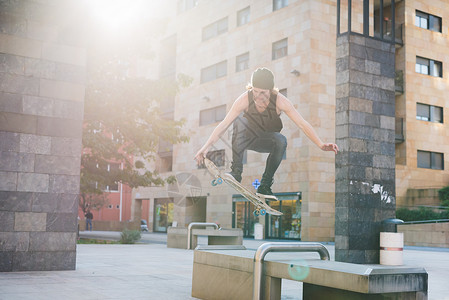 年轻男滑板运动员在城市滑滑板背景图片