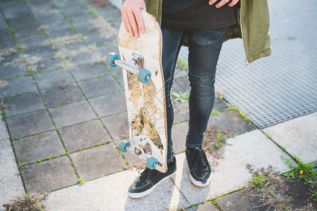 站在人行道上的年轻男城市滑板运动员图片