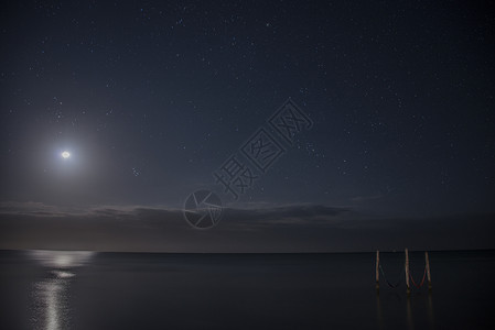 星空和满月照亮水域上的标志吊床墨西哥图片