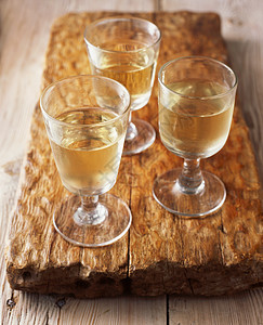 木制切割板上的白葡萄酒玻璃杯图片