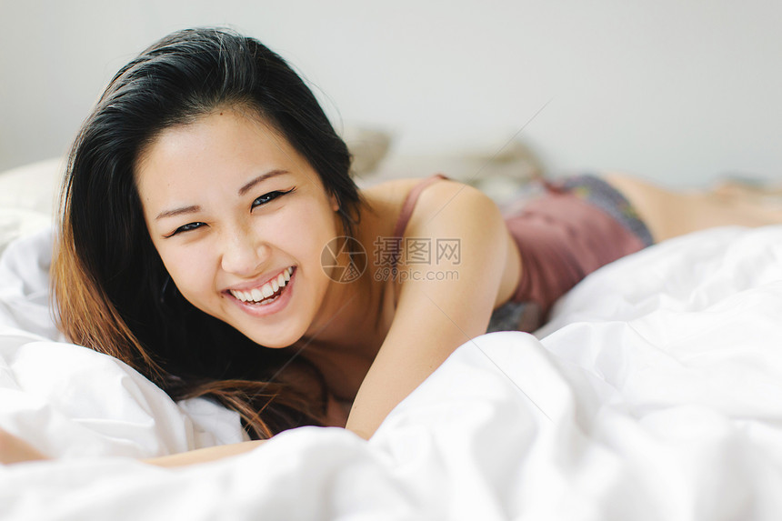 躺在床上笑着的年轻女人图片