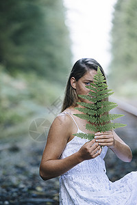 少女户外手持植物写真图片