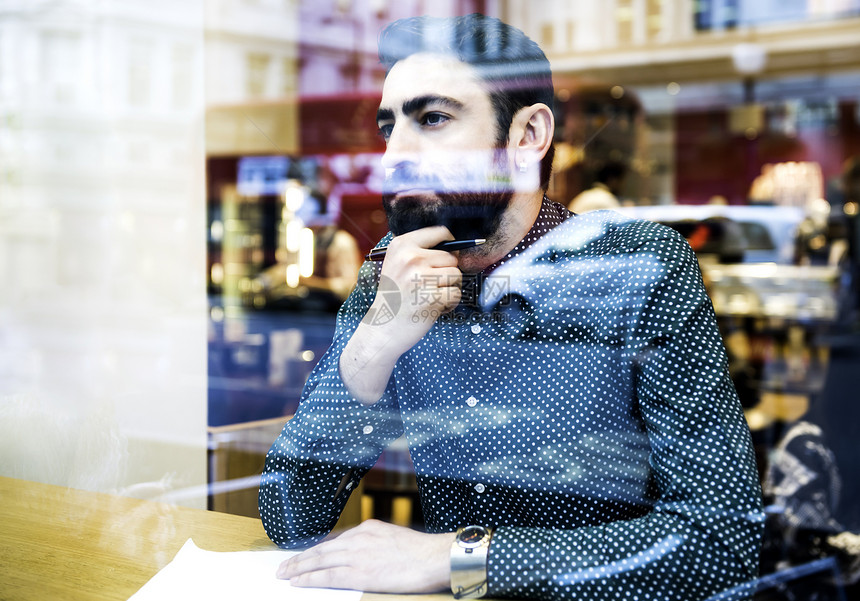 坐在咖啡馆工作思考的商务男士图片