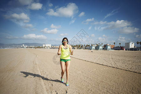 海滩边奔跑的年轻女性图片