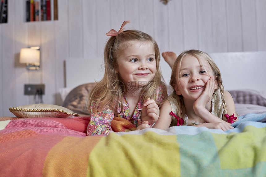 两个女孩趴在床上的肖像图片