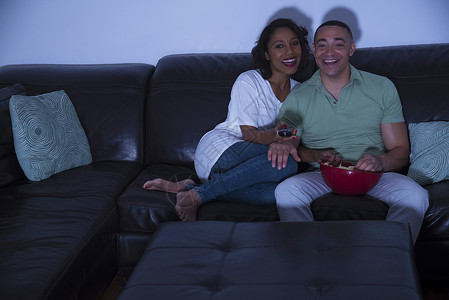 一对夫妇在沙发上吃着爆米花看电视图片