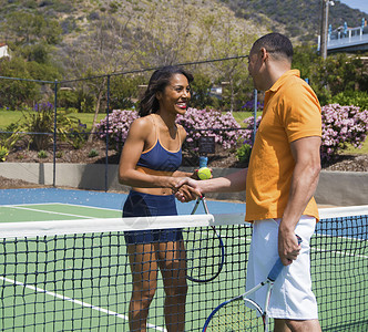 网球衫网球场边的一对夫妇在握手微笑背景