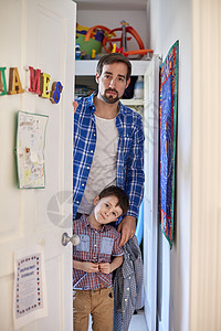 父亲和儿子在敞开的卧室门后图片