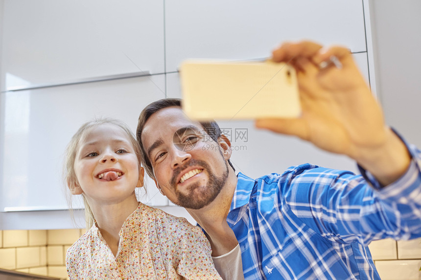 父亲和女儿在厨房拿自拍图片