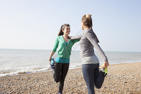 两名女性在布莱顿海滩练习一条腿站立训练图片
