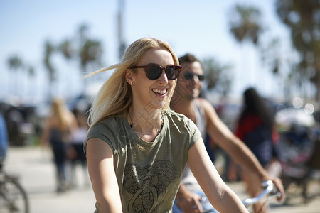 美国加利福尼亚州洛杉矶威斯海滩的年轻女子和男友骑自行车图片