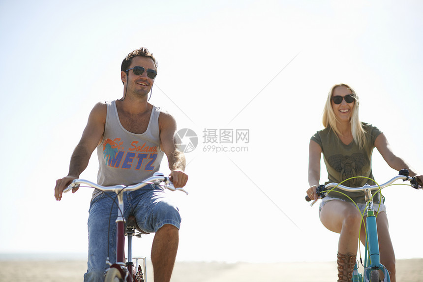 情侣在海滩骑自行车图片