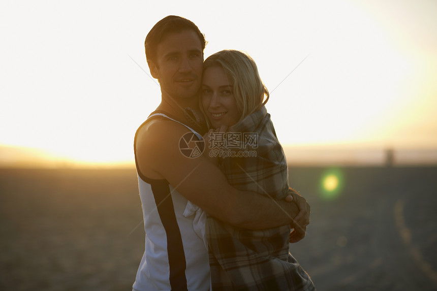 户外海滩日落时拥抱的情侣图片