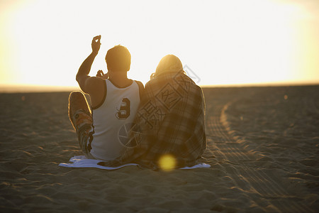 日落时在海滩上的情侣图片