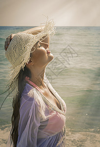 海边感受阳光的年轻女子图片