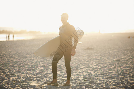 在美国加利福尼亚州日光威斯海滩携带冲浪板的男者图片