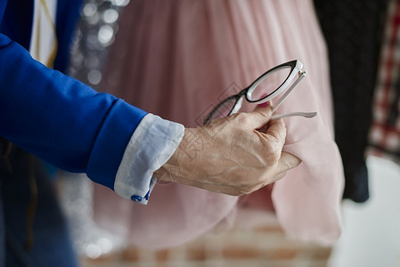 女人拿着眼镜检查裙子的手图片
