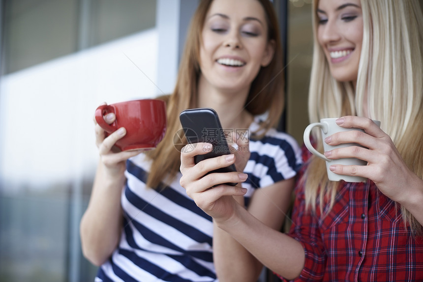 户外喝咖啡看着智能手机的朋友图片