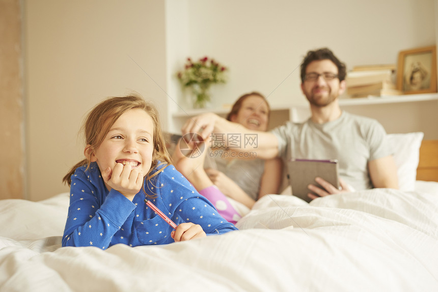 中夫妇和女儿在床上玩耍图片
