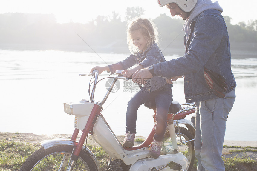 坐在父亲的摩托车上年轻女孩图片