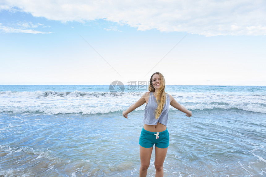 多米尼加勒比海滩上张开双臂的年轻美女图片