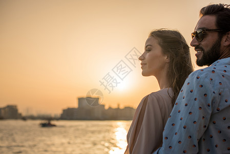 在阿拉伯联合酋长国迪拜码头观看日落的夫妇图片