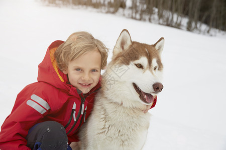 深沉沙哑的雪中男孩和宠物狗背景